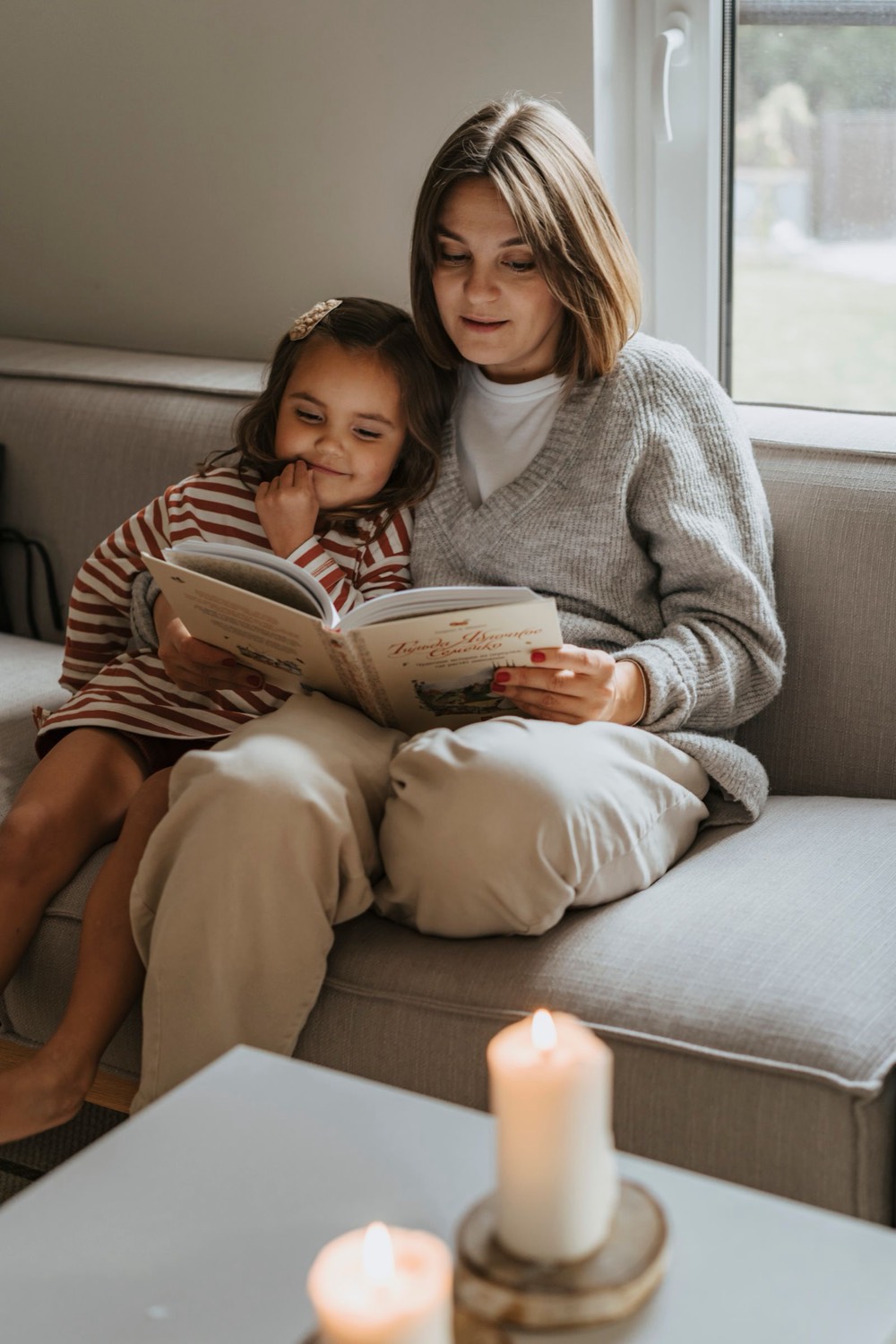 A parent and child reading together at home